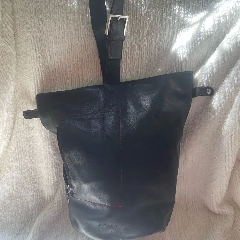 Acosta leather black bucket style shoulder bag with red stitching accents .